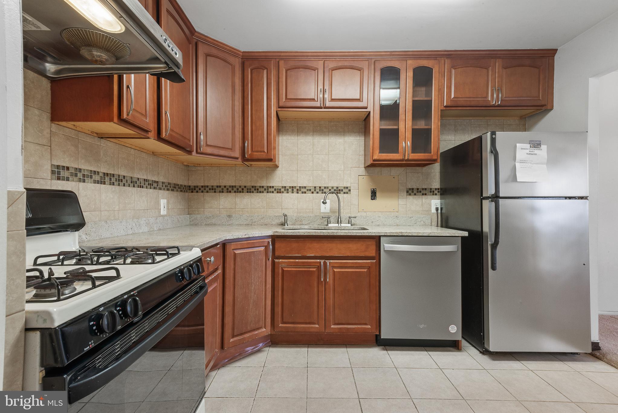 1111 University Boulevard West, Unit 805A Silver Spring, MD 20902 - Photo 15 of 33 a kitchen with stainless steel appliances granite countertop a stove top oven a refrigerator and a sink with granite countertops