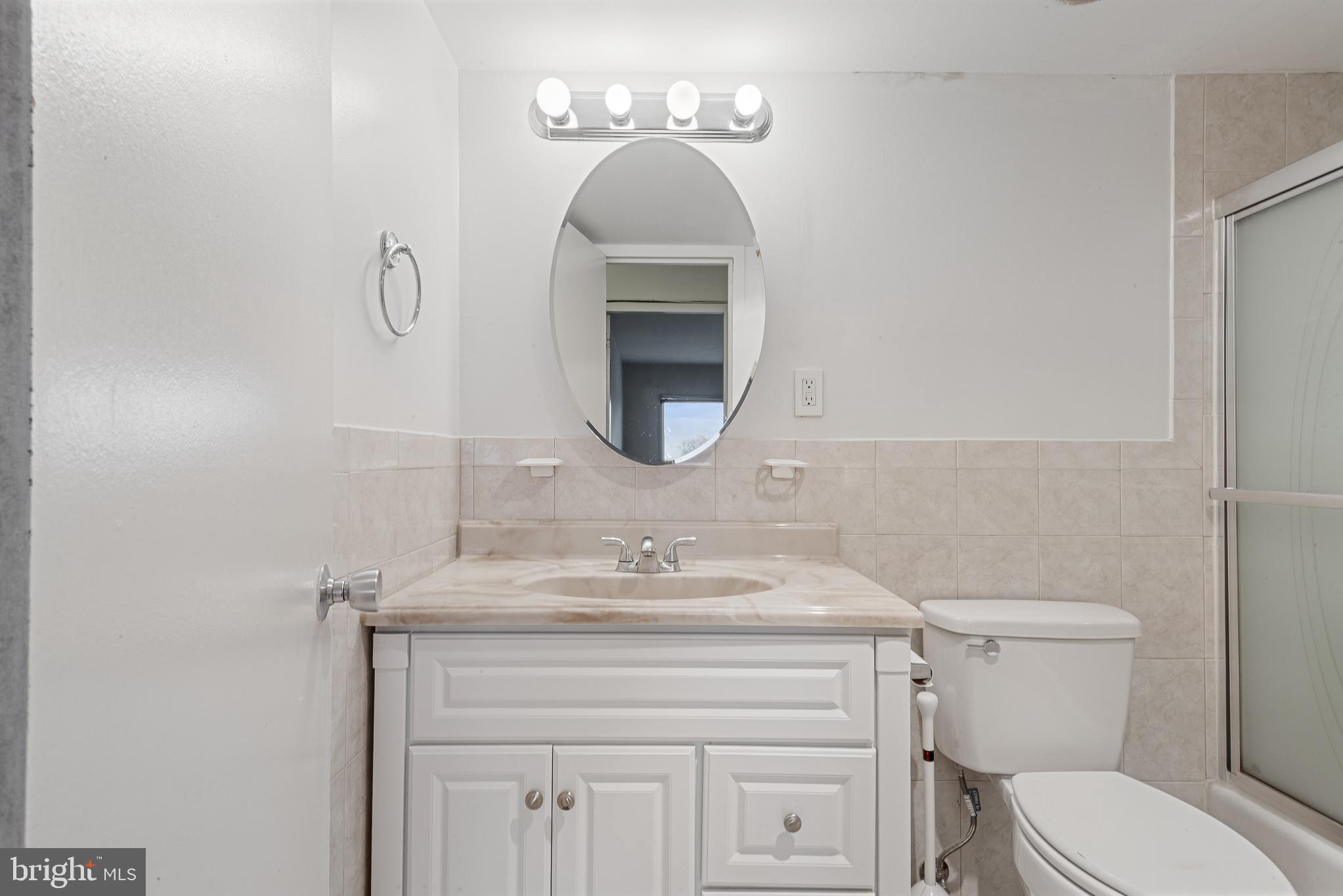 1111 University Boulevard West, Unit 805A Silver Spring, MD 20902 - Photo 9 of 33 a bathroom with a toilet sink and mirror