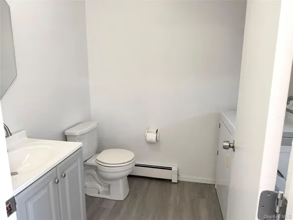 a white toilet sitting next to a white sink and vanity
