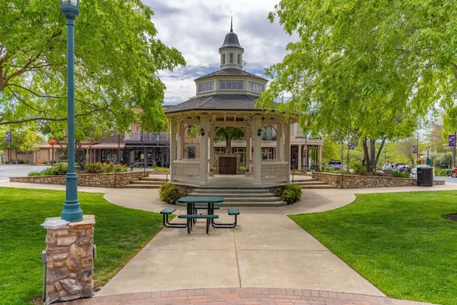 a front view of a house with garden and sitting area