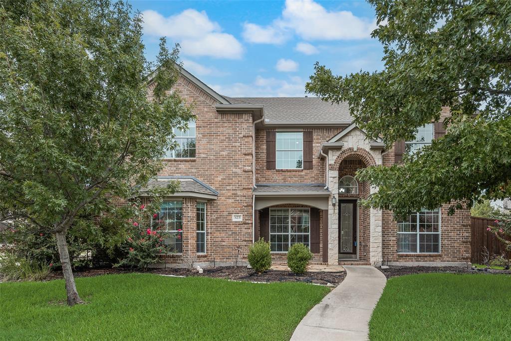a front view of a house with a garden and yard