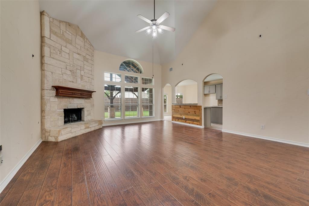 623 Lone Ridge Way Murphy, TX 75094 - Photo 9 of 40 a view of a livingroom with wooden floor a fireplace a ceiling fan and windows