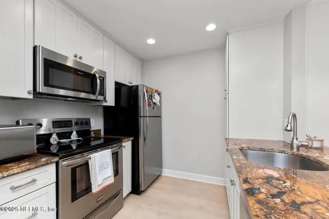 a kitchen with a sink and steel appliances