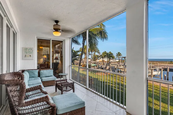 a view of a balcony with furniture and floor to ceiling window