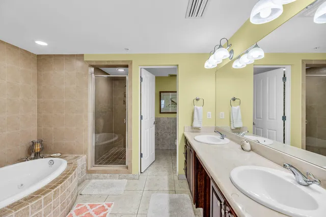 a spacious bathroom with a double vanity sink mirror and bathtub