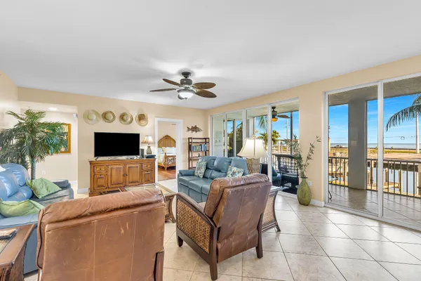 a living room with furniture a ceiling fan and a flat screen tv