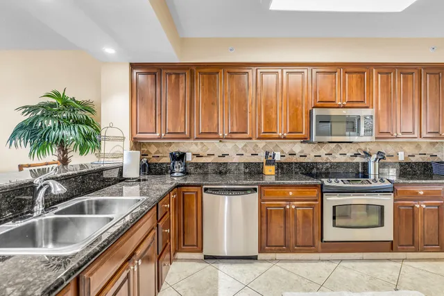 a kitchen with stainless steel appliances granite countertop a sink a stove and cabinets