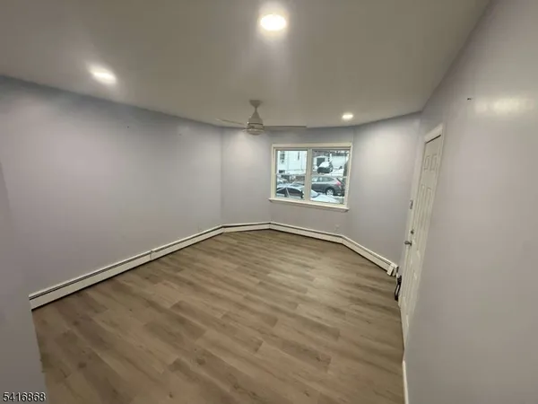 an empty room with a windows and ceiling fan