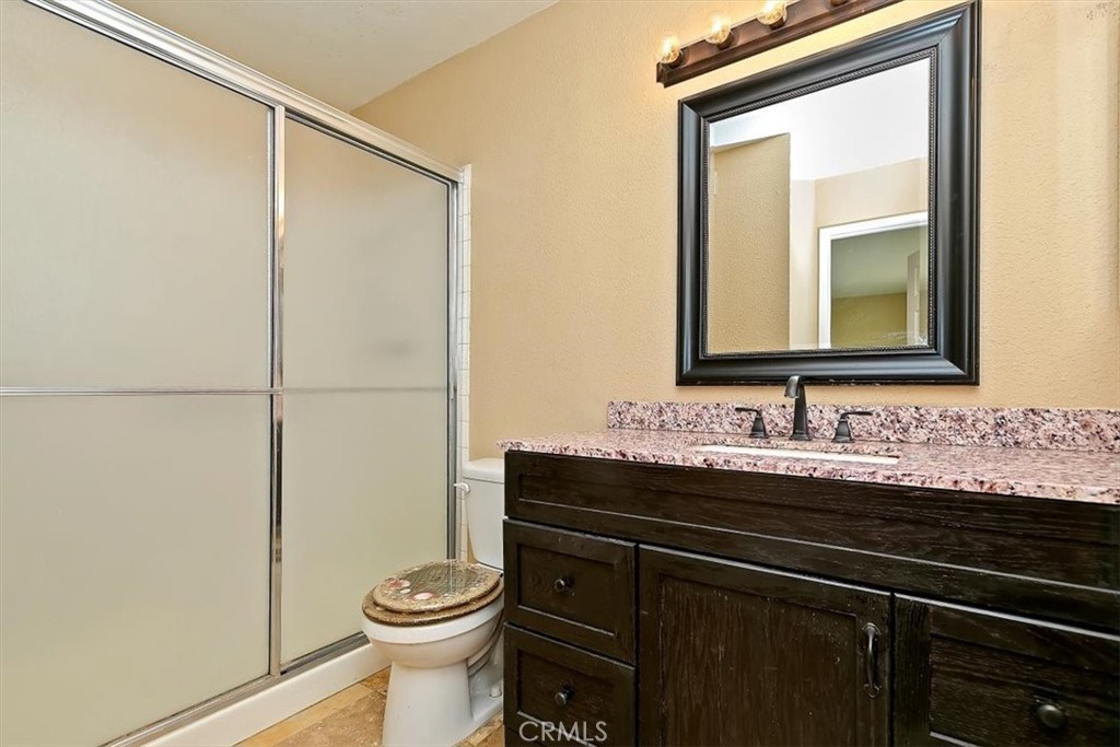 2386 Hialeah Circle Norco, CA 92860 - Photo 30 of 56 a bathroom with a granite countertop sink toilet and mirror