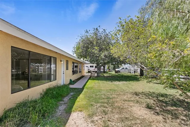 a front view of house with yard and trees in the background