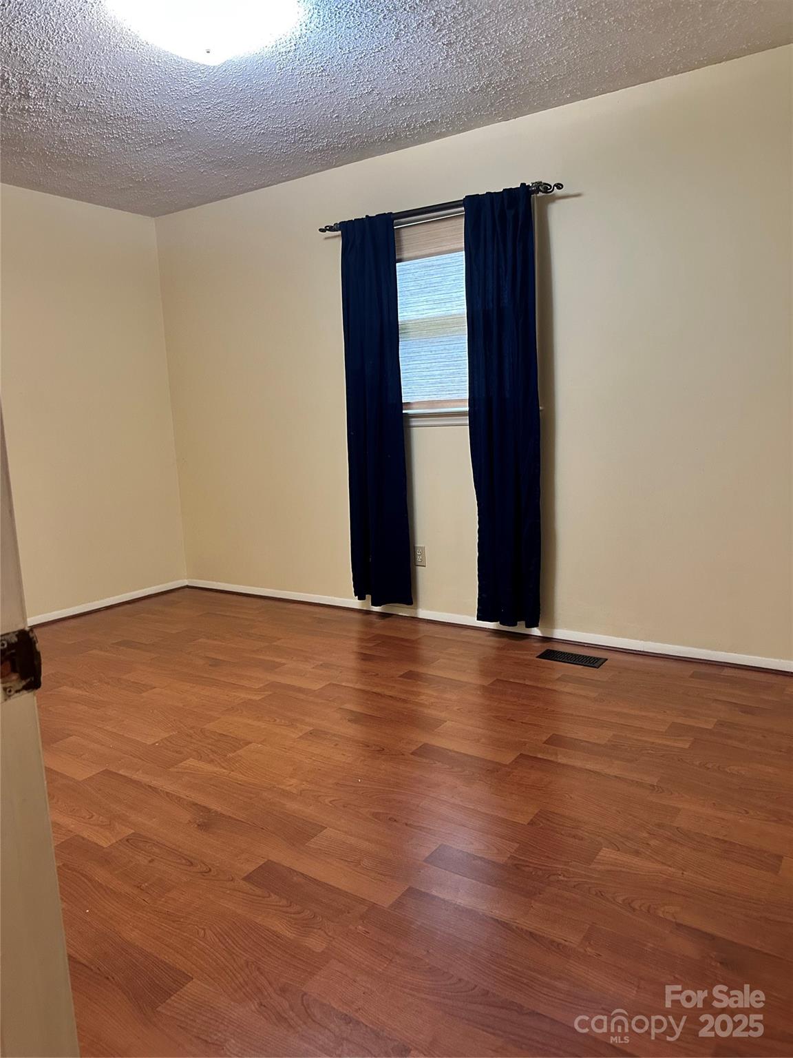 5079 Archdale Drive Conover, NC 28613 - Photo 13 of 30 an empty room with wooden floor and windows