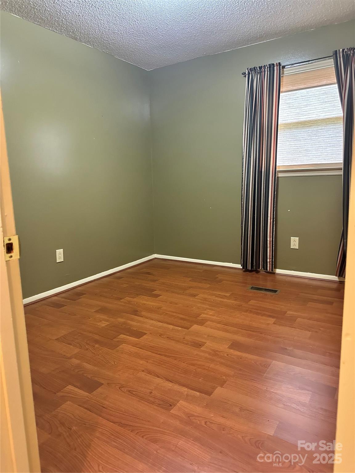 5079 Archdale Drive Conover, NC 28613 - Photo 16 of 30 an empty room with wooden floor and windows