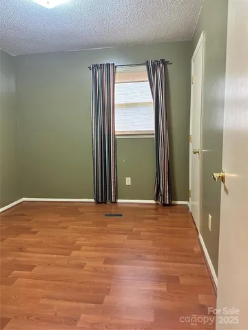 a view of an empty room with a fireplace and a window