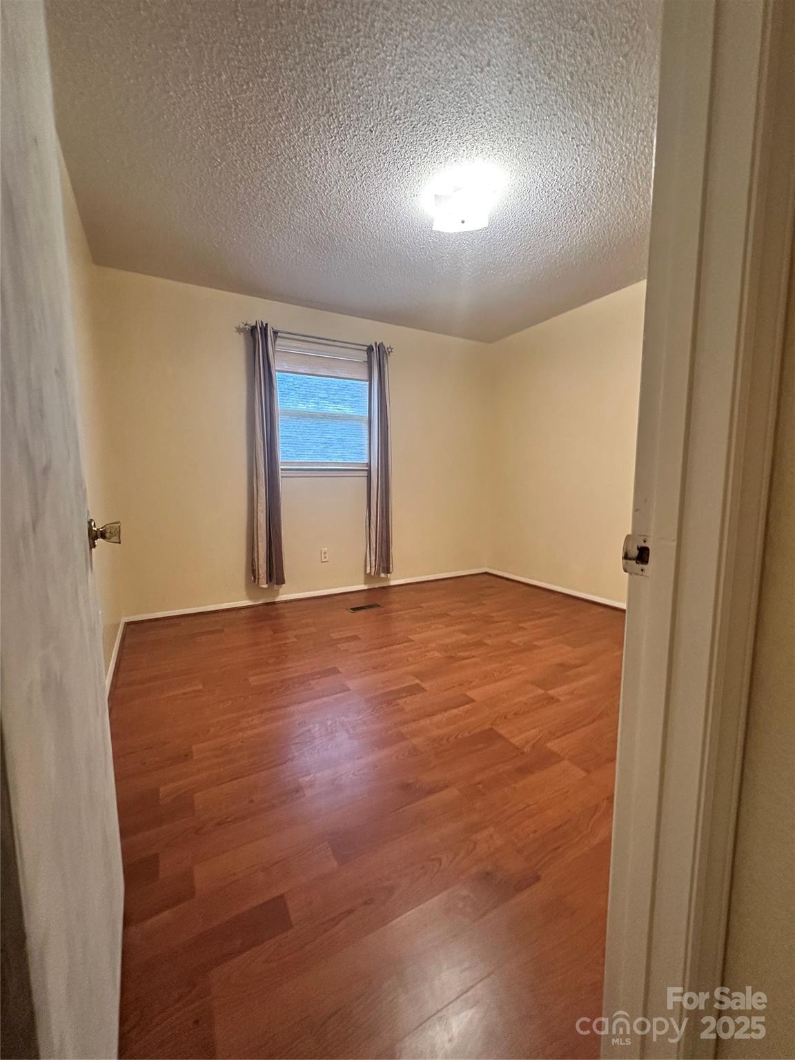 5079 Archdale Drive Conover, NC 28613 - Photo 21 of 30 an empty room with wooden floor and windows