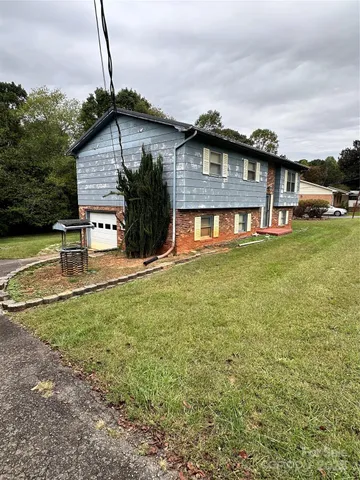 a view of a house with pool and a yard