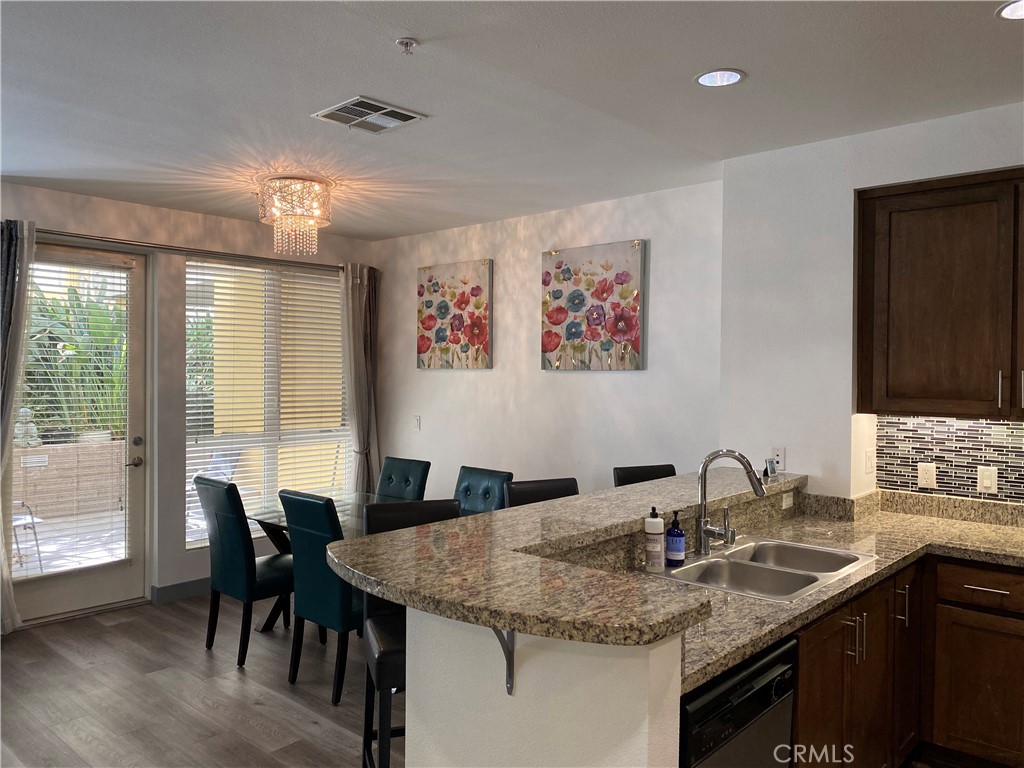a kitchen with granite countertop kitchen island a table and chairs in it