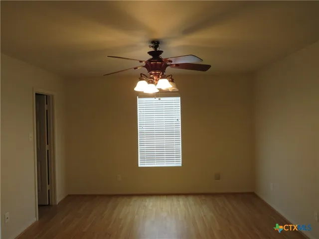 a front door view of a chandelier fan and wooden floor