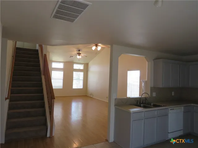 a kitchen with granite countertop a sink a stove and cabinets