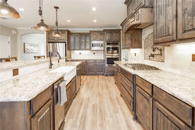 a kitchen with stainless steel appliances granite countertop a sink stove and cabinets