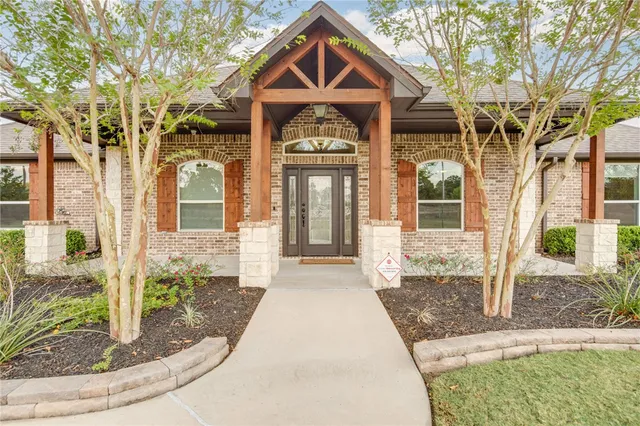 a view of a hallway with wooden floor and a bathroom