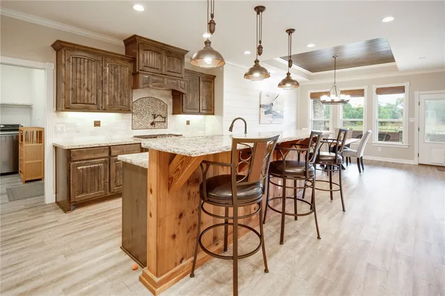 a kitchen with stainless steel appliances granite countertop a refrigerator a stove and a sink with cabinets