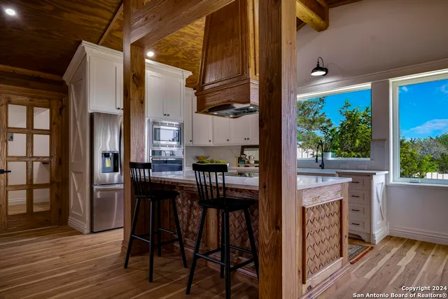 a kitchen view with table chairs and refrigerator