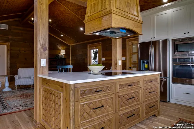 a kitchen with kitchen island a counter and a refrigerator