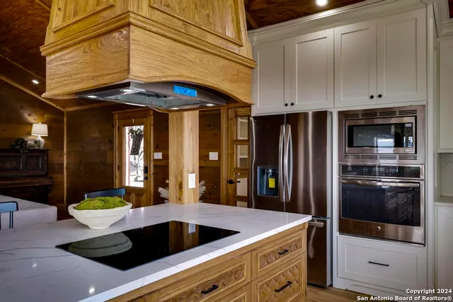 a kitchen with white cabinets and window