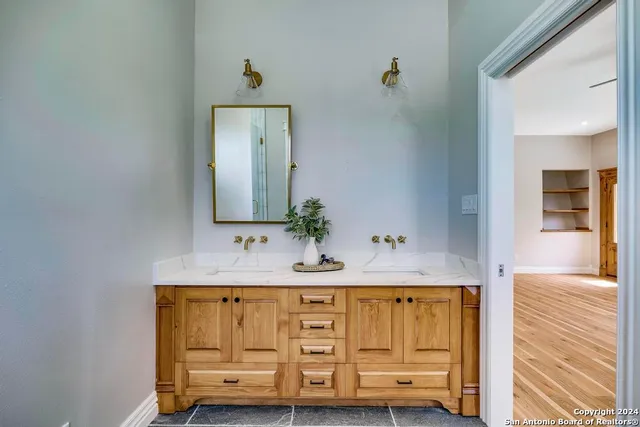 a bathroom with double sink and a mirror