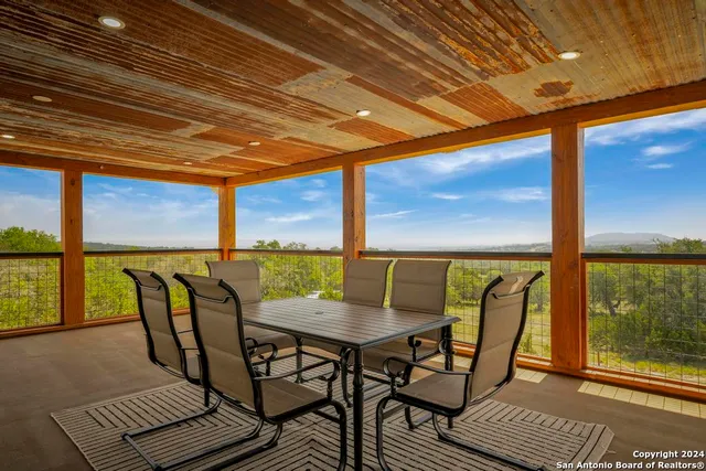 a view of a patio with a table chairs and a backyard