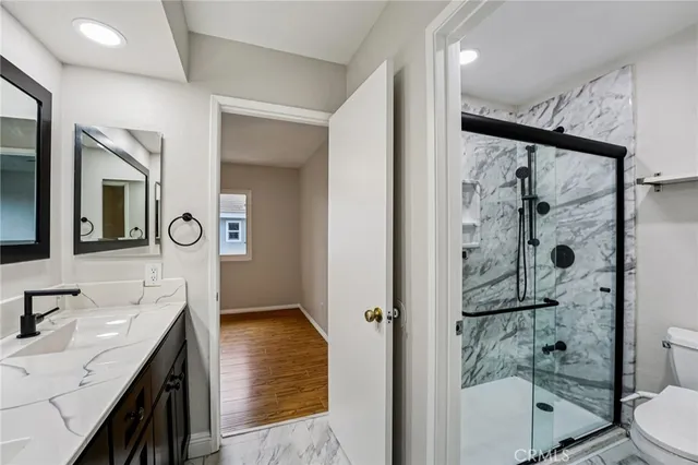a bathroom with a granite countertop sink mirror vanity and toilet