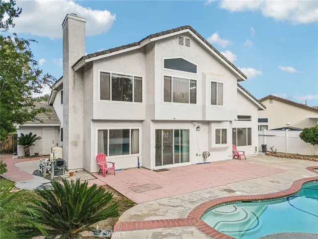 a front view of a house with a yard and potted plants