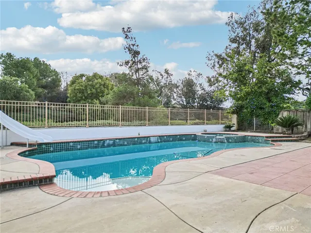 a view of a backyard with swimming pool
