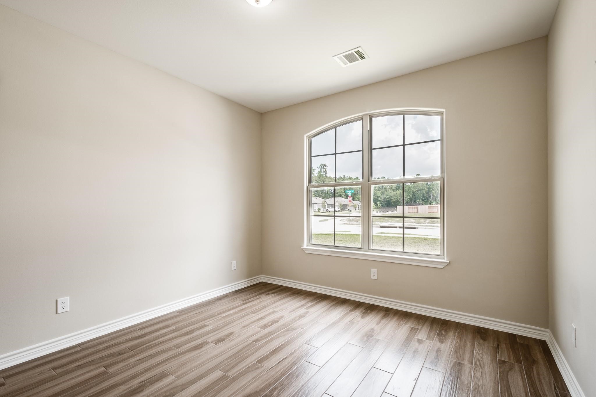 10610 Ellerston Road Cleveland, TX 77327 - Photo 5 of 26 an empty room with wooden floor and windows