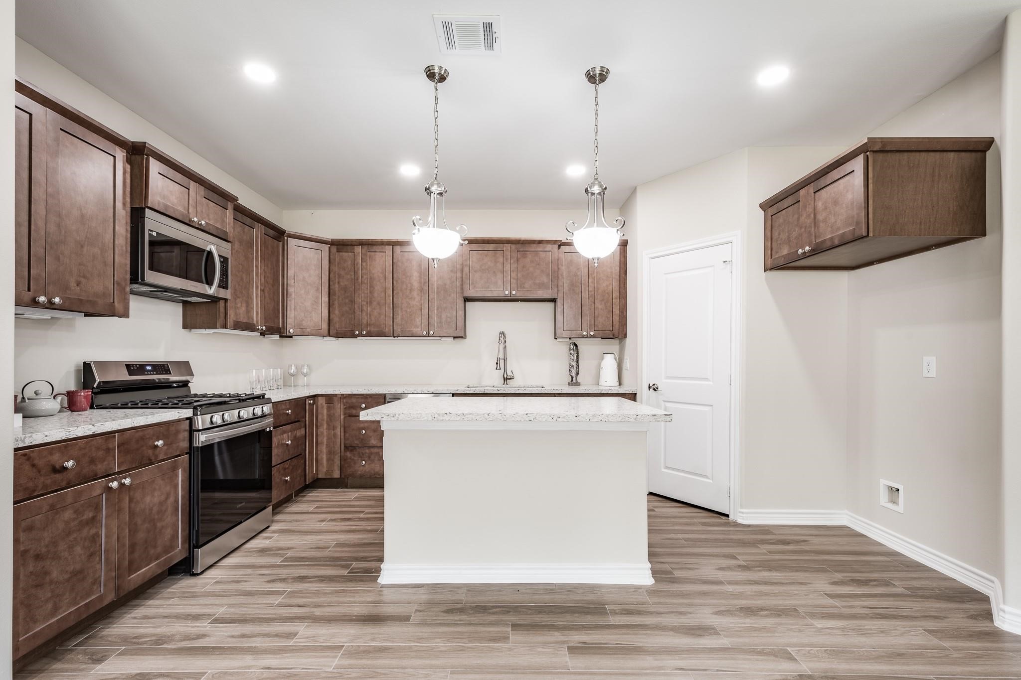 10610 Ellerston Road Cleveland, TX 77327 - Photo 9 of 26 a kitchen with stainless steel appliances granite countertop a sink a stove and a refrigerator