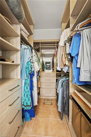 a view of walk in closet with clothes and shoes