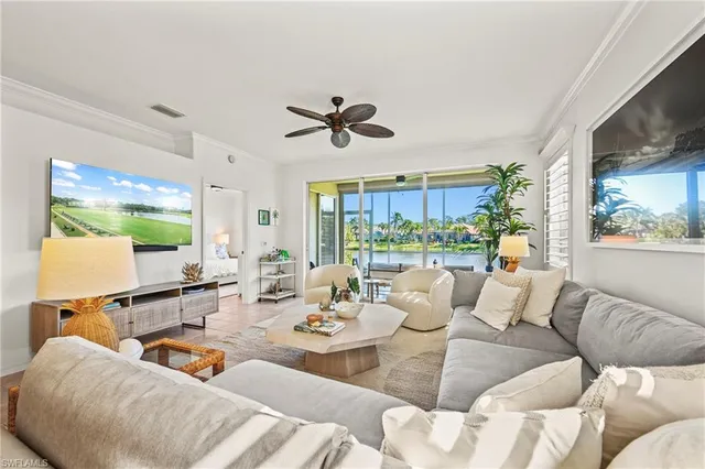 a living room with furniture kitchen view and a large window