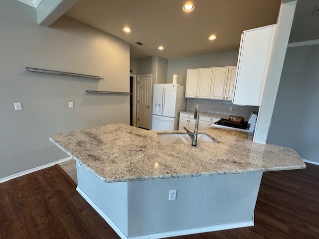 275 Bonham Loop Georgetown, TX 78633 - Photo 8 of 25 a kitchen with kitchen island a sink a refrigerator and wooden cabinets