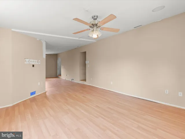 a view of a livingroom with a ceiling fan and wooden floor