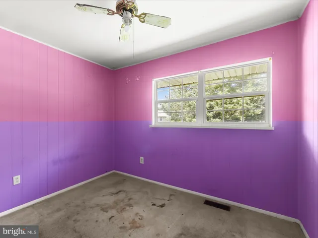 a view of empty room with fan and window