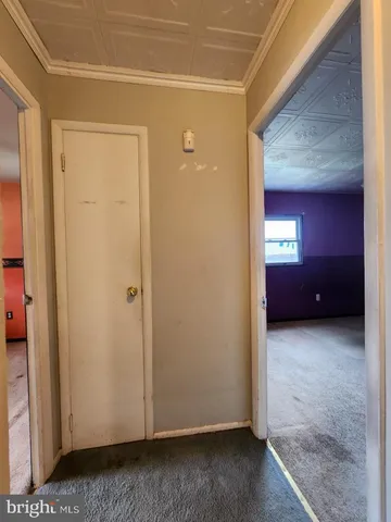 a view of an empty room with wooden floor and closet