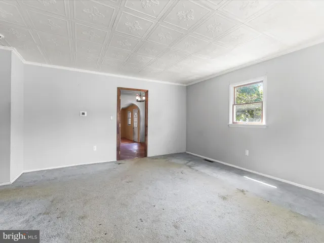 an empty room with closet and windows