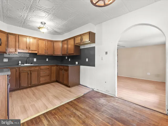 a kitchen with stainless steel appliances granite countertop a sink a stove a refrigerator cabinets and wooden floor