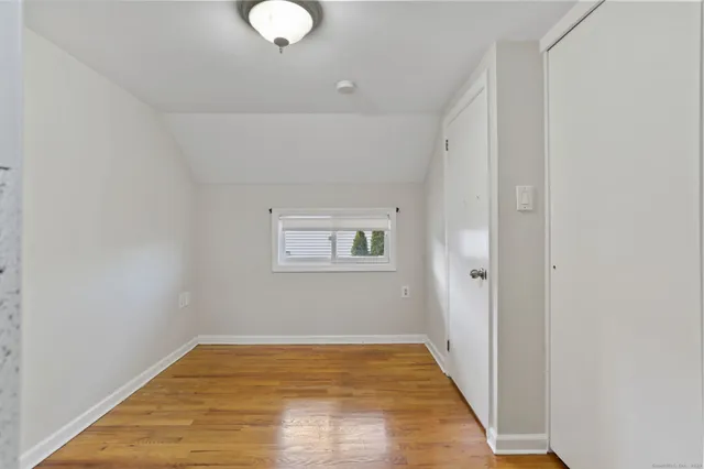 a view of empty room with wooden floor