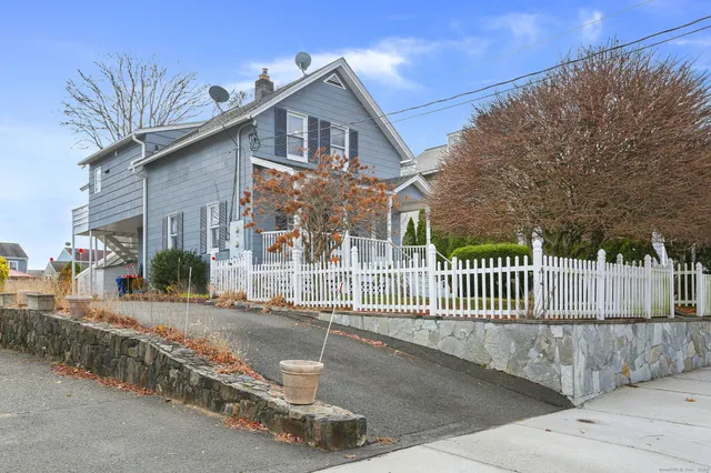 a view of a white house with large windows and a small yard