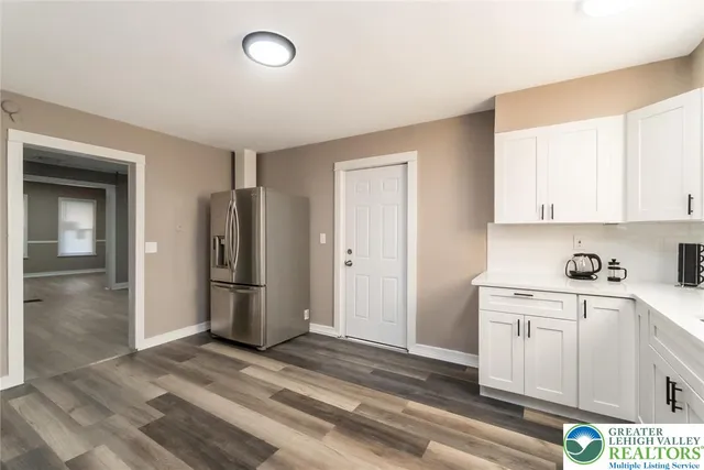 a view of a kitchen with refrigerator and window