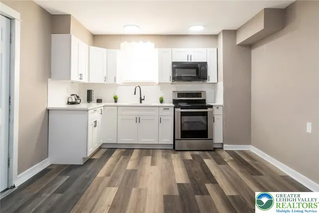 a kitchen with stainless steel appliances granite countertop a stove sink and cabinets
