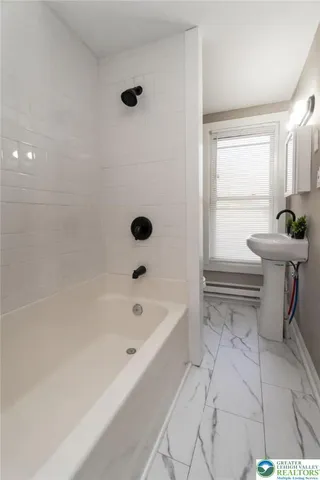 a bathroom with a bathtub sink and window