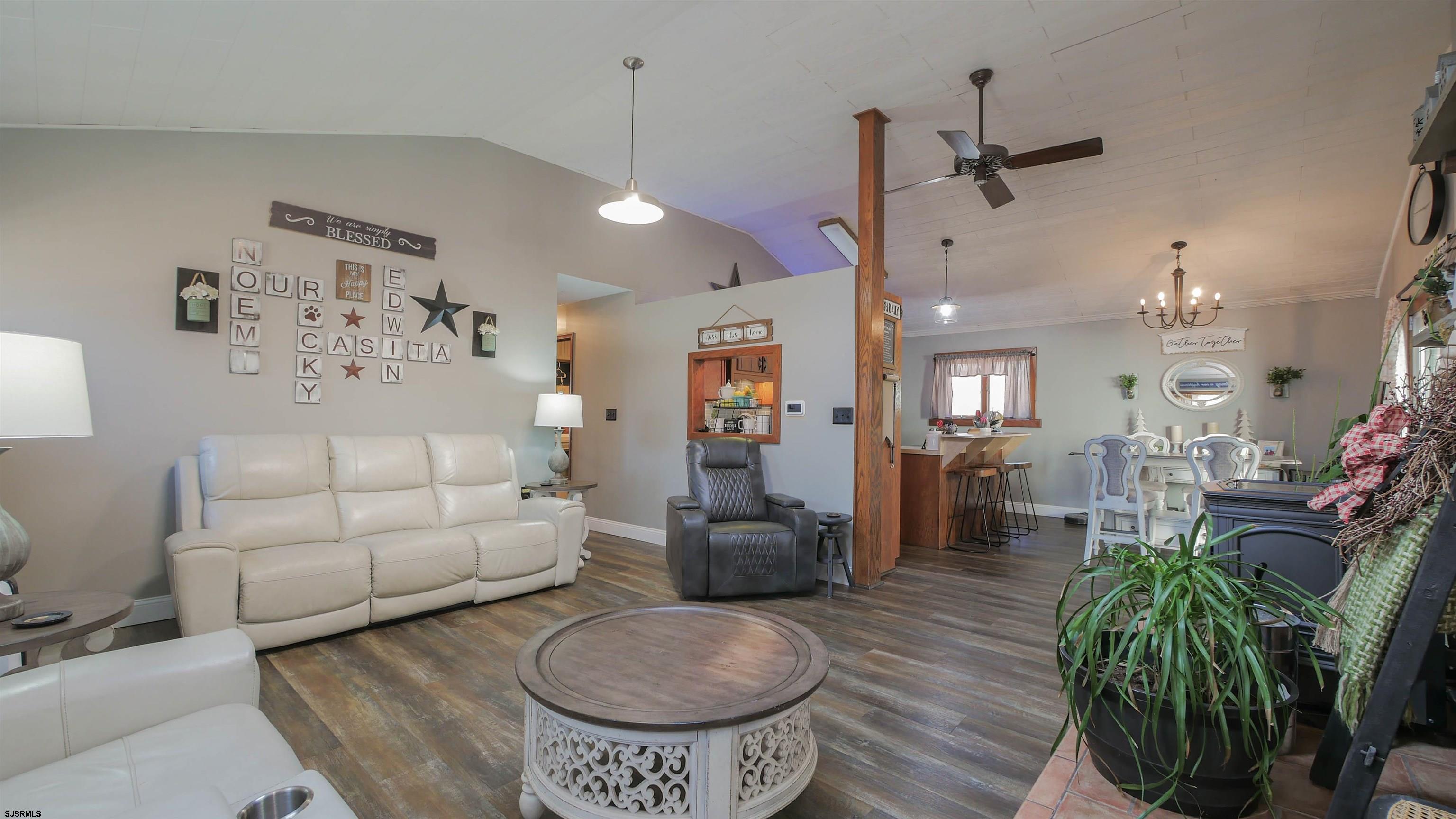 337 Broad Street Milmay, NJ 08330 - Photo 16 of 36 a living room with furniture a chandelier and wooden floor
