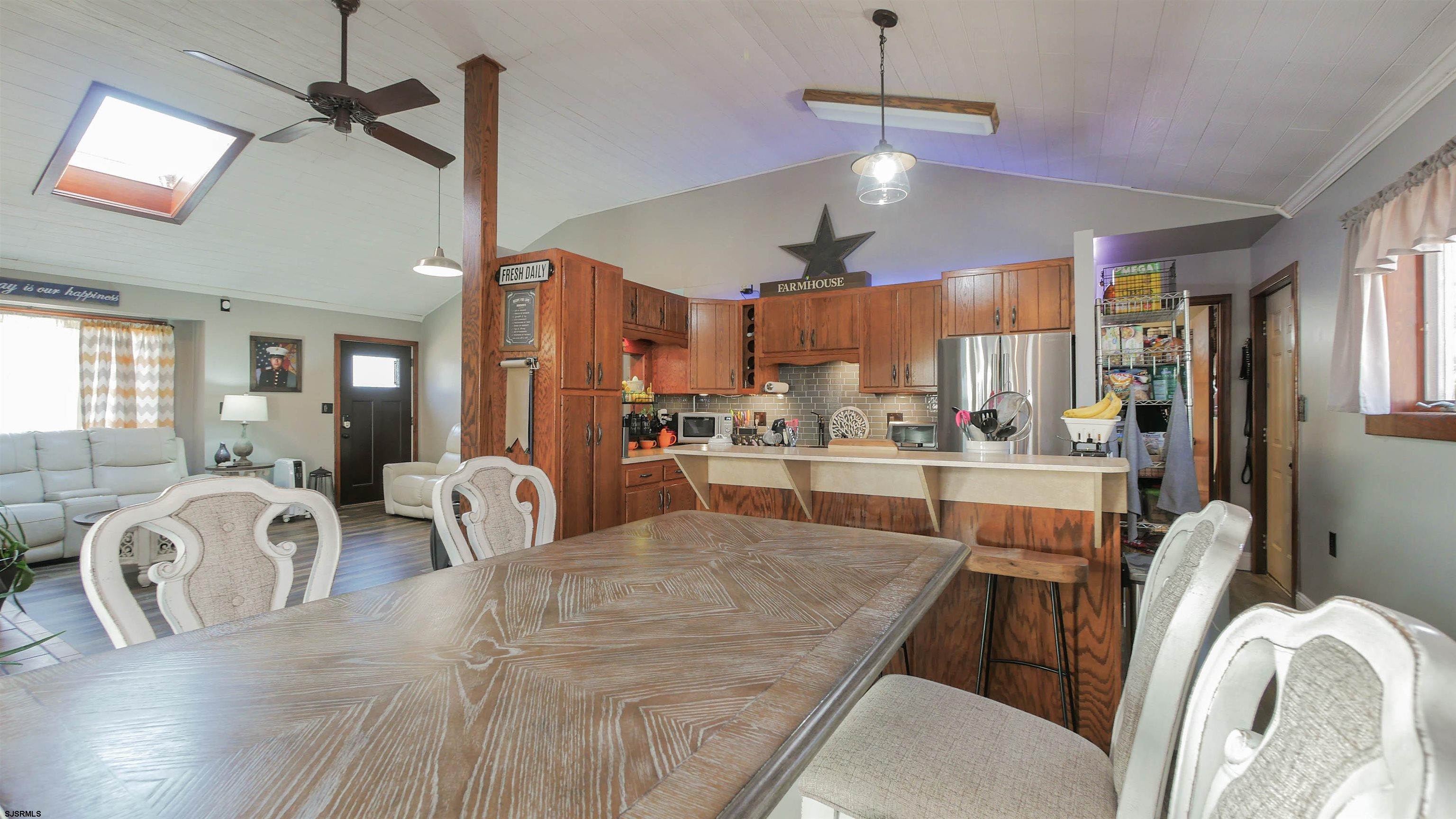 337 Broad Street Milmay, NJ 08330 - Photo 17 of 36 a open kitchen with stainless steel appliances granite countertop a stove refrigerator a dining table and chairs with wooden floor
